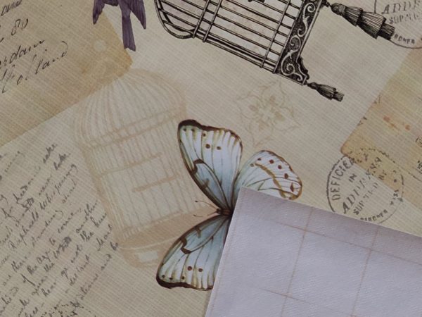 Πλατικό ύφασμα για τραπεζομάντηλο με πεταλούδες, κλουβιά, πουλιά, γράμματα, καρτ ποστάλ και σφραγίδες.
